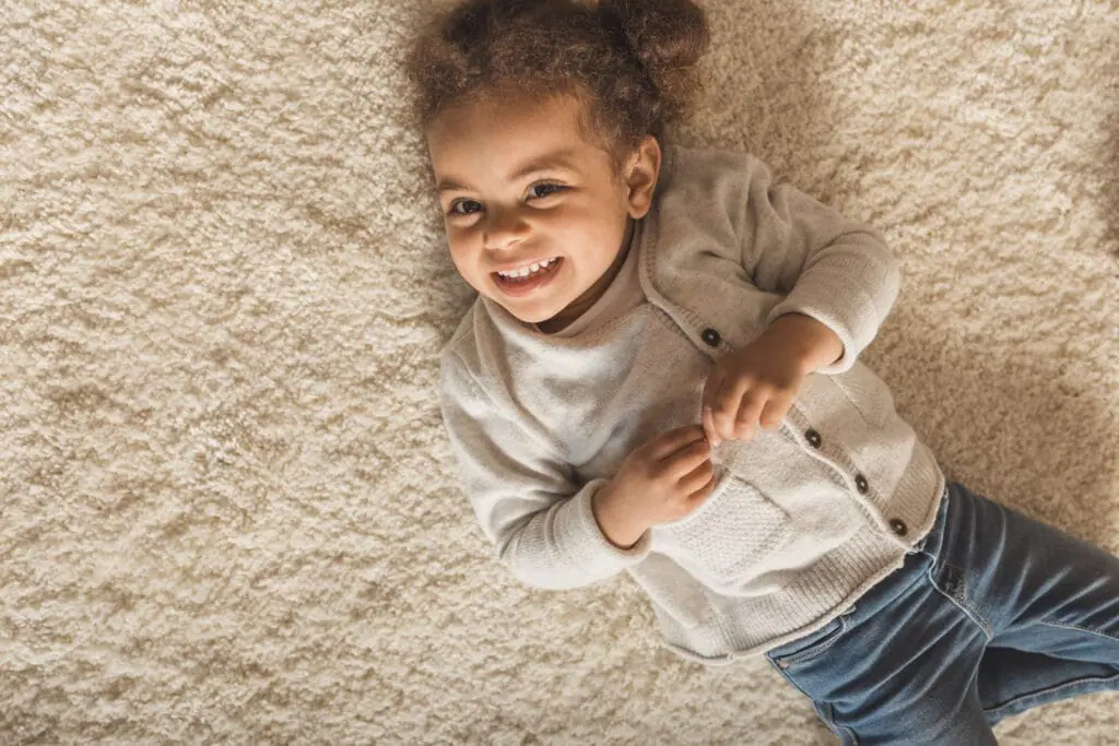 Cute little girl relaxing on brand new plush carpet