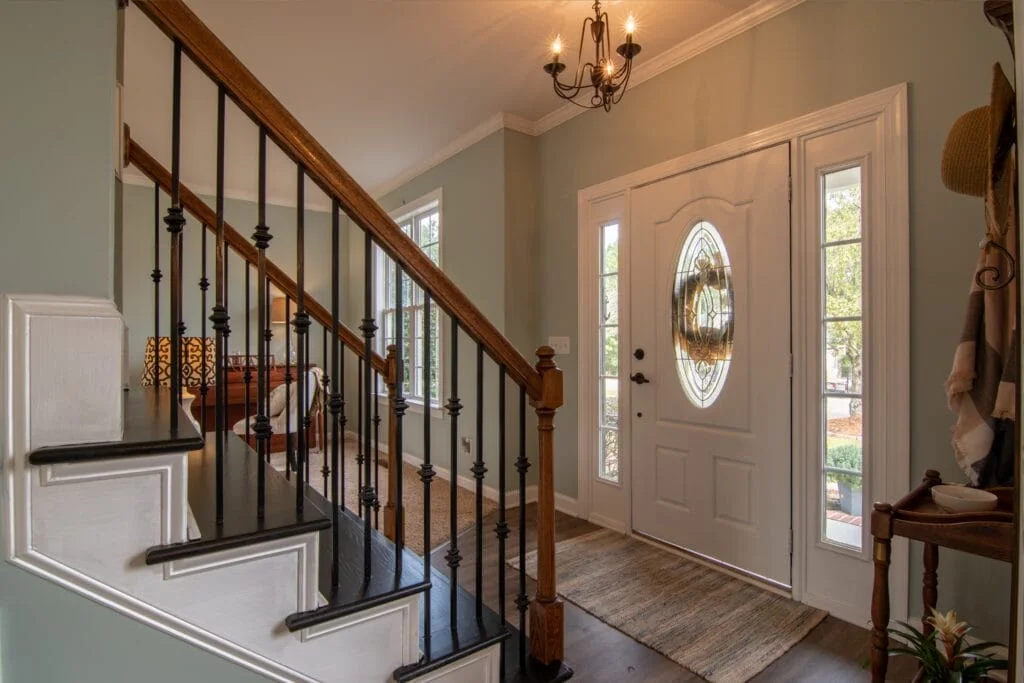 Modern entry way with staircase fitted with iron banister railings.